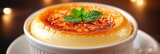 Delicious crème brûlée garnished with mint leaves under warm lighting