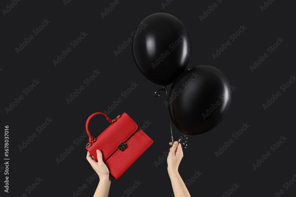 Woman holding bag with balloons on dark background. Black Friday Sale