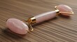 © ARI - Pink rose quartz facial roller on a wooden surface.