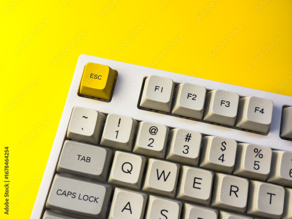 White mechanical keyboard with bright Esc key on bright yellow ...