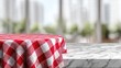 © Fastabikul - Round red-and-white checkered tablecloth on a marble tabletop, blurred city background