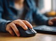 © Hamzi - Close-up of person using a black computer mouse on a laptop