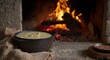 © Den Boro Day - Rustic potato soup in a cast iron pot by the fireplace, cozy comfort food.