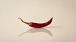 © Den Boro Day - Single Red Chili Pepper with Reflection on a Neutral Background, a Spicy Ingredient.