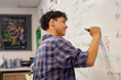 © Rido - Teen student writing equation on whiteboard in classroom