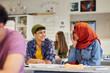 © Rido - Multiethnic teens students talking in classroom