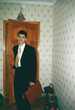 © Masson - Young man in suit holding briefcase on first day of university, analog photo taken in home hallway early 2000s Ukraine with vintage atmosphere