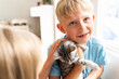 © ADDICTIVE STOCK - Young boy hugging a grey kitten in a cozy home setting