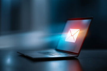 A glowing laptop screen displays a digital email icon, emitting light, symbolizing digital communication and online correspondence. This image evokes a sense of connection and modernity.