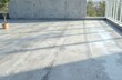 © Vadym - Concrete flat roof texture before waterproof insulation installation. Gray building material shows wear, with shadows of railing and faint water stains on surface. Ready for renovation and protection.