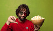 © kues1 - young adult bearded man. popcorns and movie concept