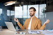 © Liubomir - Businessman meditating at workplace desk for stress relief and mindfulness