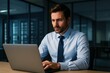 © Tanakorn - Handsome business executive concentrates intensely on his laptop, illuminated by its glow in the modern office, conveying focus and intelligence.