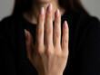 © SuperImages - Close view of a woman’s hand with elegant manicured nails displayed against a dark background