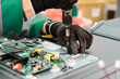 © nordroden - Worker assembling electronic components in a television manufacturing plant during daytime operations
