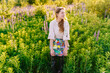 © Iryna - Female artist in meadow holding colorful paint palettes