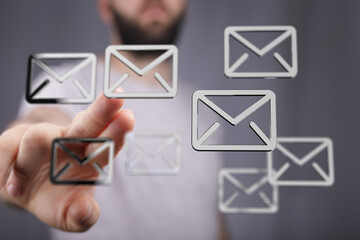A man interacts with holographic email icons, representing digital communication and email marketing.