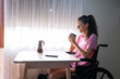 © Arianne - Smiling woman in wheelchair enjoying morning coffee at home