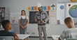 © Framestock - Teacher Inviting Construction Worker, Man Speaking to Curious Students About Work on Construction Site. Children Listening Attentively During Career Education Lesson at Elementary School. Slow Motion.
