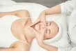 © elenavolf - Caucasian female receiving facial massage in spa with therapist s hands on face in relaxing atmosphere.