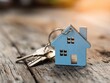 © The - A light-blue wooden house keychain rests alongside house keys on a weathered wooden surface.
