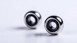 © The - Two metallic bearings, round and reflective, sit on a light background, showcasing precise engineering and clean lines.