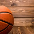 © nurdin - Close up of an orange basketball on a wooden floor and wall.