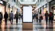 © Pixim Stock - Blank digital advertising screen in the center of a busy modern shopping mall with blurred shoppers walking past