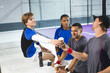 © Wavebreak Media - Diverse male teammates in sports gear sitting on squash court passing coffee cup next to bottle