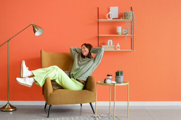 Poster - young woman sitting in armchair at home