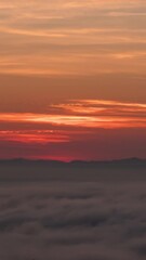 Wall Mural - Time lapse vertical video of dramatic sunrise with fog on a cloudy morning.