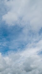 Wall Mural - Beautiful summer day sky with fluffy white clouds time lapse in bright blue atmosphere.
