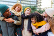 © Xavier Lorenzo - Young group of multiracial friends in warm clothes having fun on winter outside. Diverse teenage Gen Z students hanging out and laughing while enjoying free day at city street. Friendship concept