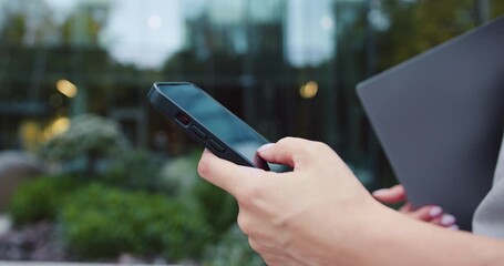Close up of woman hand use phone. Hand of woman using texting mobile phone or chat. Outdoors