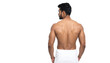 © TransPicHub - A muscular man stands with his back turned, wearing a white towel, highlighting his strong physique.