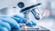 © MarkelovaVision - A close-up shot shows a scientist using a microscope to study a sample in the lab.