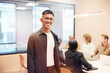 © Johnér - Portrait of smiling businessman wearing eyeglasses standing in office board room