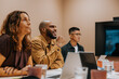 © Johnér - Smiling businessman sitting with colleagues in meeting room at office
