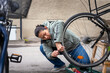 © Johnér - Full length of woman repairing puncture of cycle