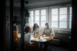 © Johnér - Male and female business professionals sitting at conference table in office board room