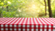 © AYESHA - Red and white checkered picnic tablecloth with blurred green nature background