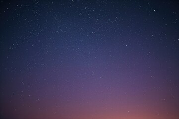 Wall Mural - night sky filled with stars and the first light of dawn