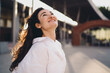 © BullRun - Smiling woman in white shirt looking upward with optimistic expression outdoors. Conceptual portrait of freelancer lifestyle symbolizing empowerment, positivity, and digital future.