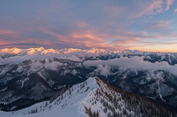 Wall Mural - extensive panoramic view of snowy peaks and expansive mountain ridges at dusk, with clouds drifting 