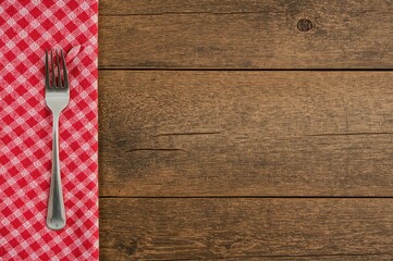 Wall Mural - Utensil resting on classic wooden surface with red and white plaid cloth