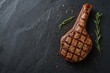 © vxnaghiyev - Wide banner showcasing a medium rare grilled T-bone or premium porterhouse steak seasoned and presented on a slate serving board, ideal for catering menus and recipes, overhead view