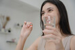 © Thitiporn - Woman holding a red and blue capsule pill in hand, preparing to take medicine for health care or treatment. Ideal for medical, pharmaceutical, or wellness-related content and campaigns.