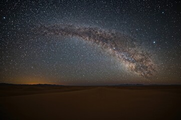 Wall Mural - a breathtaking wide-angle shot of the milky way stretching over expansive desert dunes at night.