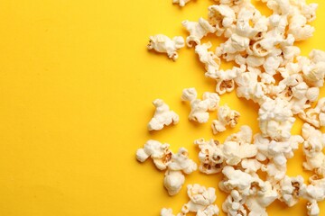 Wall Mural - Tasty popcorn on yellow background, flat lay. Space for text