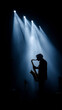 © Auraclicks - Silhouette of jazz musician playing saxophone on stage with bright spotlight beams